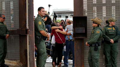 Separated children and families embrace between Mexico and the United States.